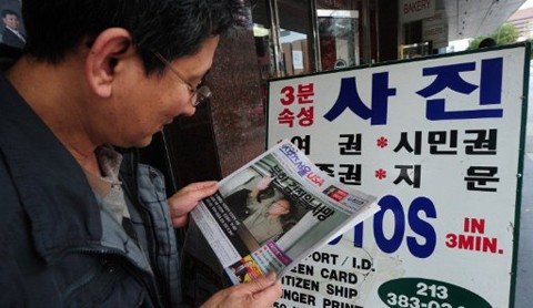 Một người Mỹ gốc Triều Tiên đọc báo đưa tin về sự ra đi của chủ tịch Kim Jong-il. Ảnh: AFP